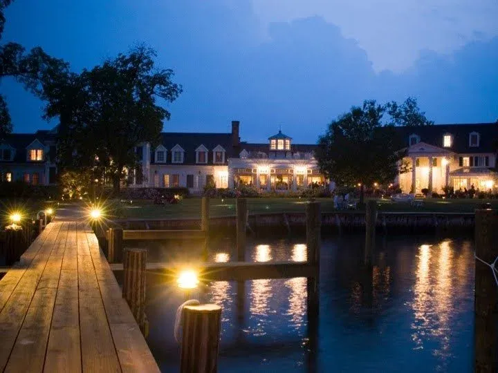 Waterfront venue glowing in the evening beside a dock.