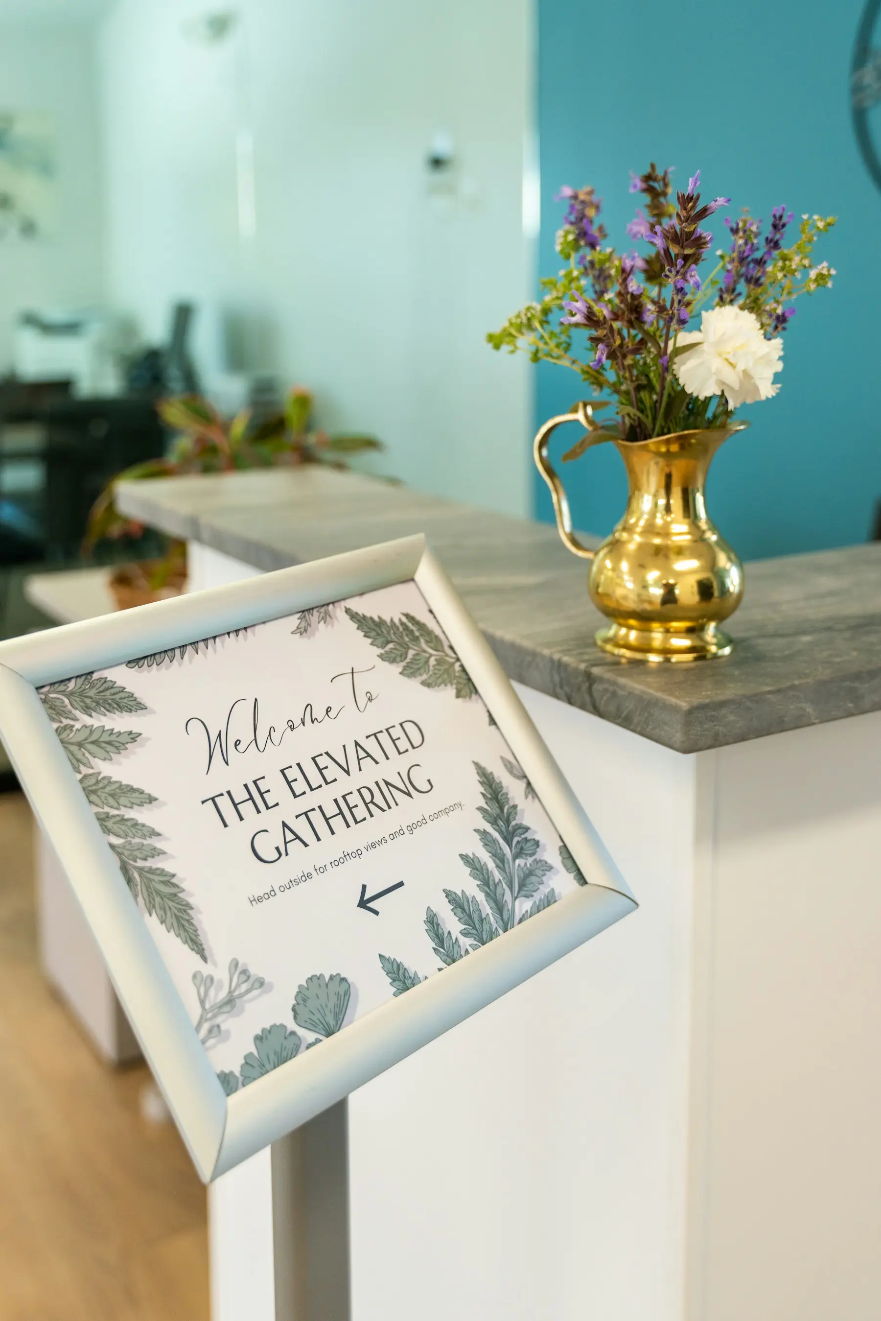 Guests gathered near event signage in a reception setting.